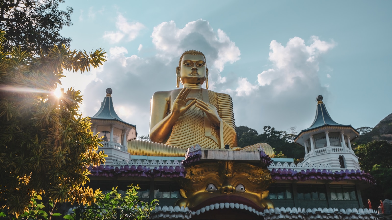 gold buddha statue under cloudy sky during daytime