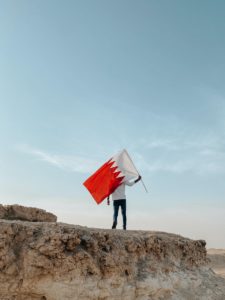 Man Standing on the Rock with a Flag of Bahrain