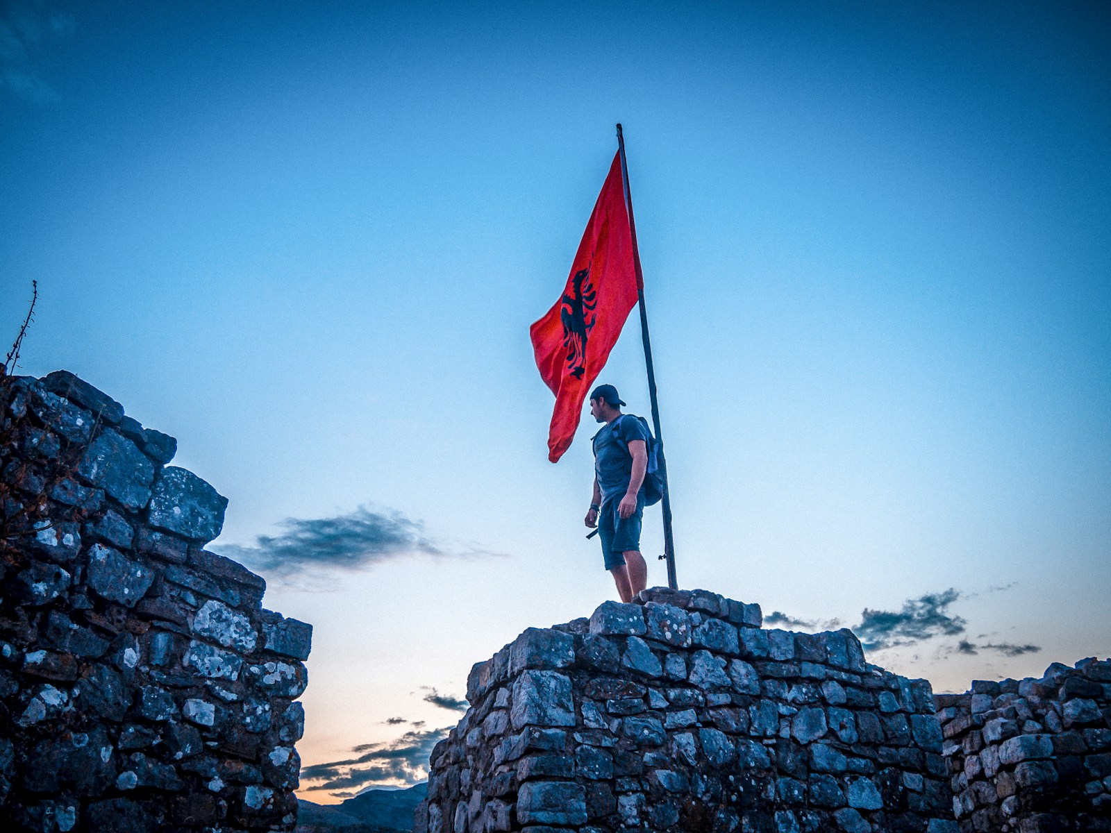 a person standing on a rock with a flag